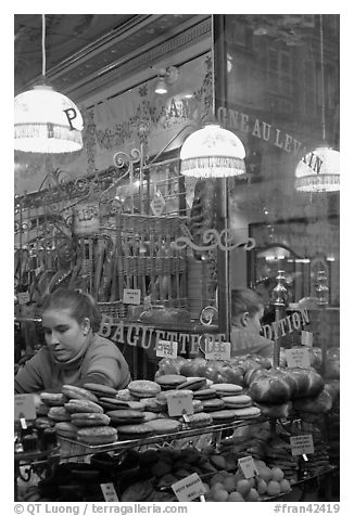 Woman selling pastries and bread in bakery. Paris, France (black and white)