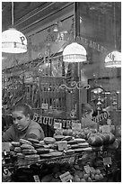 Woman selling pastries and bread in bakery. Paris, France (black and white)