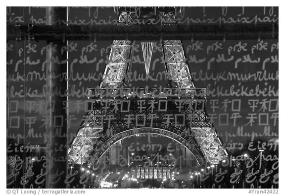 Lit Eiffel Tower seen through the words Peace written in many languages. Paris, France