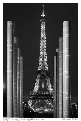 Columns of memorial to peace end Eiffel Tower by night. Paris, France