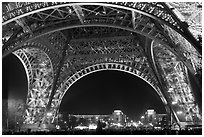 Palais de Chaillot seen through the base of Eiffel Tower by night. Paris, France (black and white)