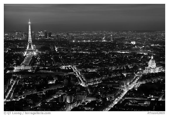 Aerial view at night with Eiffel Tower, Invalides, and Arc de Triomphe. Paris, France