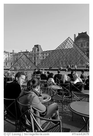 Couple sitting on terrace in Louvre main courtyard. Paris, France