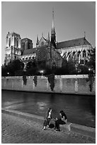 Two women having picnic across Notre Dame cathedral. Paris, France (black and white)