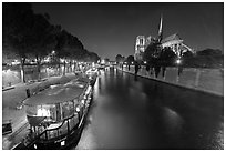 Quay, lighted boats, Seine River and Notre Dame at night. Paris, France ( black and white)