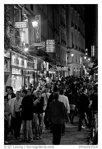 Busy pedestrian street at night. Quartier Latin, Paris, France (black and white)