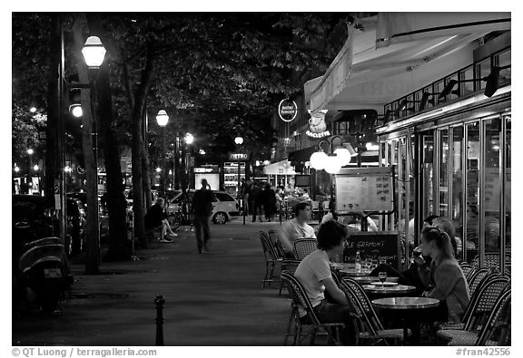 Outdoor cafe terrace on the Grands Boulevards at night. Paris, France (black and white)