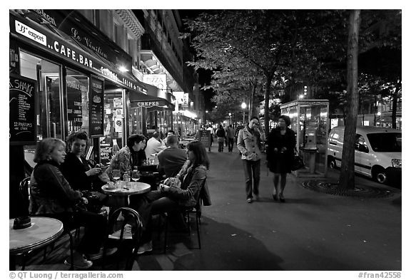 Cafe bar on sidewalk of a Grand Boulevard at night. Paris, France