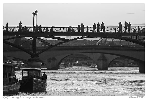 Seine river and people silhouettes on Pont des Arts. Paris, France