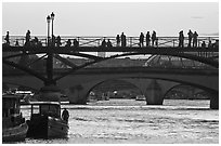 Seine river and people silhouettes on Pont des Arts. Paris, France (black and white)