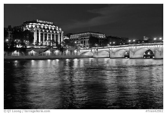 Pont Neuf and Samaritaine reflected in Seine River at night. Paris, France