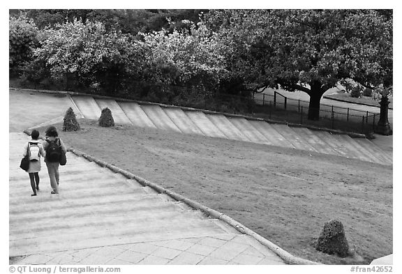 Couple walking down steps in park, Montmartre. Paris, France (black and white)