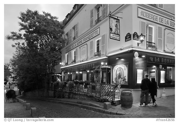Couple looking at menu outside restaurant, Montmartre. Paris, France (black and white)