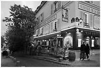 Couple looking at menu outside restaurant, Montmartre. Paris, France (black and white)