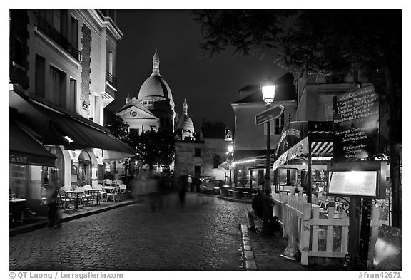 Place du Tertre at night with restaurants and Basilique du Sacre-Coeur, Montmartre. Paris, France (black and white)