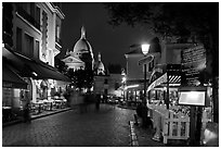 Place du Tertre at night with restaurants and Basilique du Sacre-Coeur, Montmartre. Paris, France (black and white)