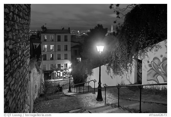 Hillside stairs of butte Montmartre and street lights at sunset. Paris, France (black and white)