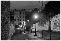 Hillside stairs of butte Montmartre and street lights at sunset. Paris, France (black and white)