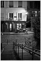 Hillside stairs on butte, street and restaurant at night, Montmartre. Paris, France ( black and white)