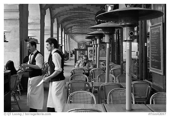 Waiters and cafe in place Victor Hugo arcades. Paris, France