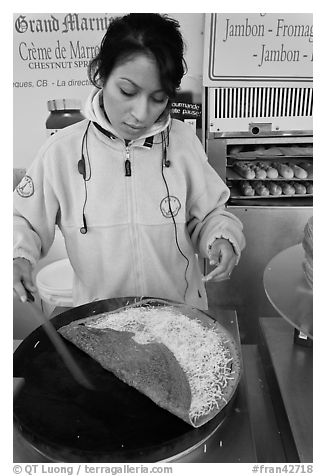 Woman preparing a crepe with cheese. Paris, France (black and white)