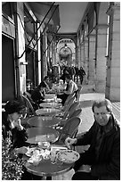 Couple eating at an outdoor table in the Palais Royal arcades. Paris, France (black and white)