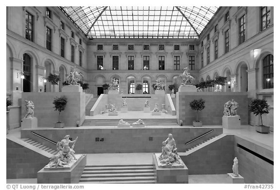 Louvre Museum room with sculptures and skylight. Paris, France