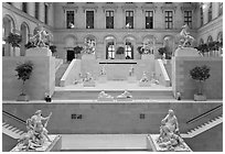 Ancient sculptures in display in Louvre Museum room. Paris, France ( black and white)