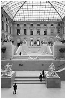 Tourists and exhibit inside Louvre museum. Paris, France (black and white)