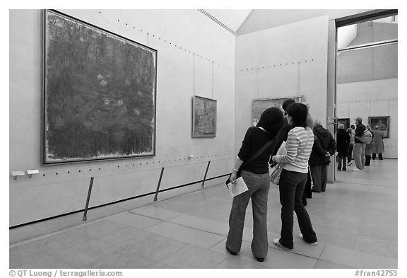 Tourists looking at a large impressionist painting of a lilly pond. Paris, France (black and white)
