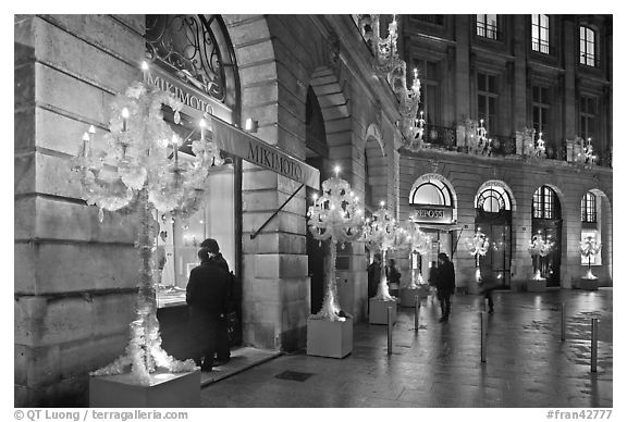 Looking at the storefronts of luxury stores at night, Place Vendome. Paris, France