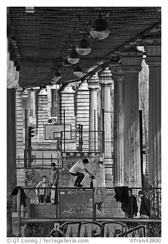 Youngsters skateboarding below metro bridge. Paris, France