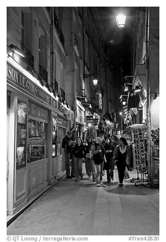 People walking in pedestrian street at night. Quartier Latin, Paris, France (black and white)