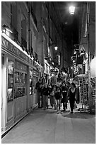 People walking in pedestrian street at night. Quartier Latin, Paris, France ( black and white)