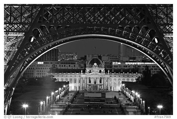 Ecole Militaire (Military Academy) seen through Eiffel Tower at night. Paris, France