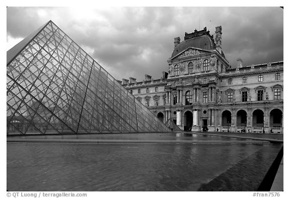 Pyramid and Richelieu wing of the Louvre under dark clouds. Paris, France