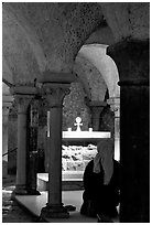 Nun in prayer in the Crypte of the Romanesque church of Vezelay. Burgundy, France ( black and white)