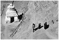 People ascending a trail past a chorten below Phuktal,  Zanskar, Jammu and Kashmir. India (black and white)