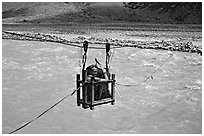 Trekker crossing a river by cable, Zanskar, Jammu and Kashmir. India (black and white)