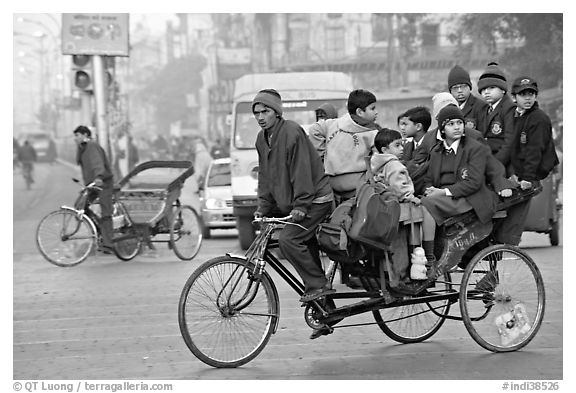 Cycle-rickshaw with a load of ten schoolchildren. New Delhi, India (black and white)