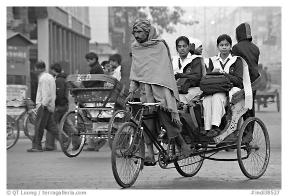 Cycle-rickshaw carrying uniformed schoolgirls. New Delhi, India (black and white)