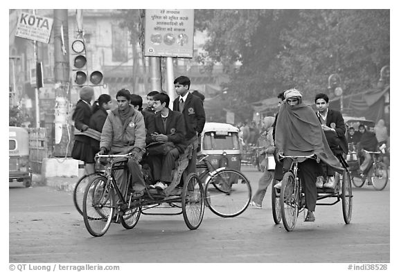 Cycle-rickshaws carrying uniformed schoolchildren. New Delhi, India (black and white)