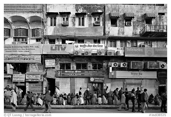 Street with many people waiting in front of closed stores, Old Delhi. New Delhi, India (black and white)