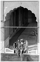 Women standing beneath arched entrance of prayer hall, Jama Masjid. New Delhi, India (black and white)