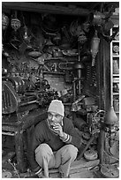 Man sitting in front of machine parts shop, Old Delhi. New Delhi, India (black and white)