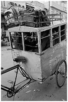 Schoolchildren in an enclosed  box towed by cycle. New Delhi, India (black and white)