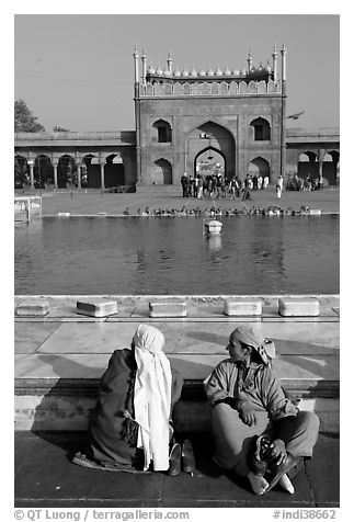 Women sitting near basin in courtyard of Jama Masjid. New Delhi, India (black and white)