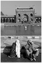Women sitting near basin in courtyard of Jama Masjid. New Delhi, India ( black and white)