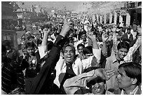 Young men celebrating and spraying wedding party in the street. Jodhpur, Rajasthan, India (black and white)