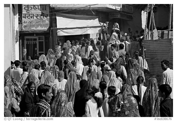 Street with women in colorful sari following wedding procession. Jodhpur, Rajasthan, India (black and white)